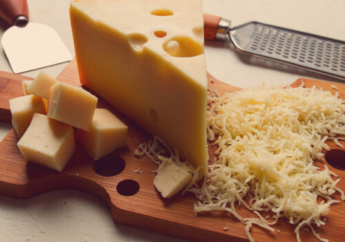 Grated cheese, Maasdam, on a cutting board, grater and cheese knife, close-up, no people,